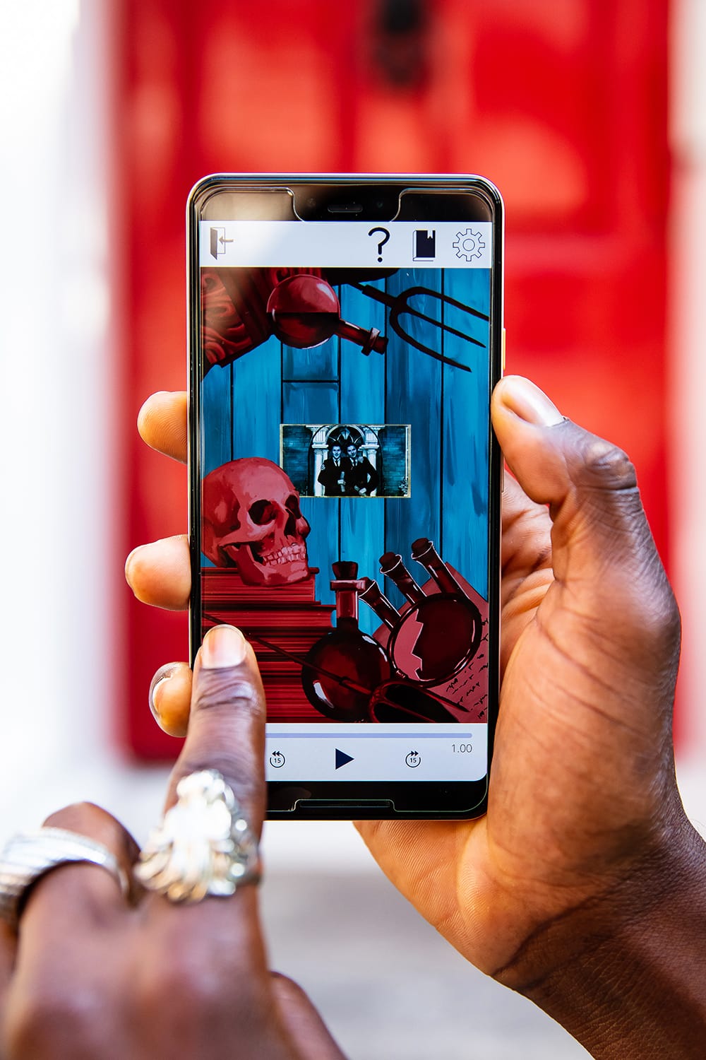 A close-up of a man's hands, holding a smartphone. On the screen a puzzle is visible and the man is pressing the screen to solve the puzzle