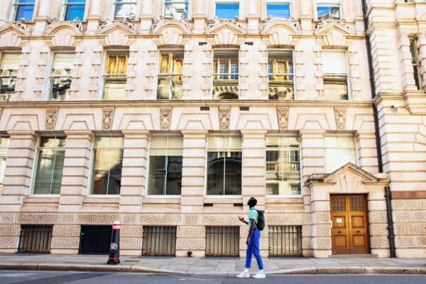 A young man wearing blue pants and a green tshirt is walking the Dr Jekyll and Mr Hyde tour in London