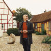 A man is standing by two half-timbered houses