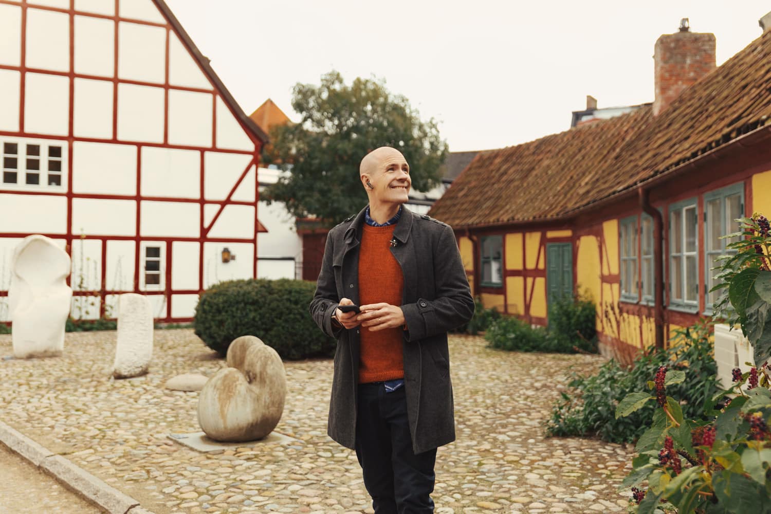 A man is standing by two half-timbered houses