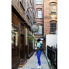 A young man in a green shirt is looking up at a sign that says Ye Olde Cheshire Cheese