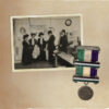 An old album with a photo of a group of women and a medal in the suffragette colors