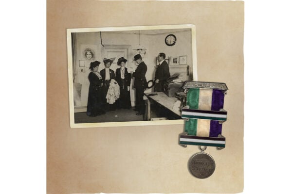 An old album with a photo of a group of women and a medal in the suffragette colors