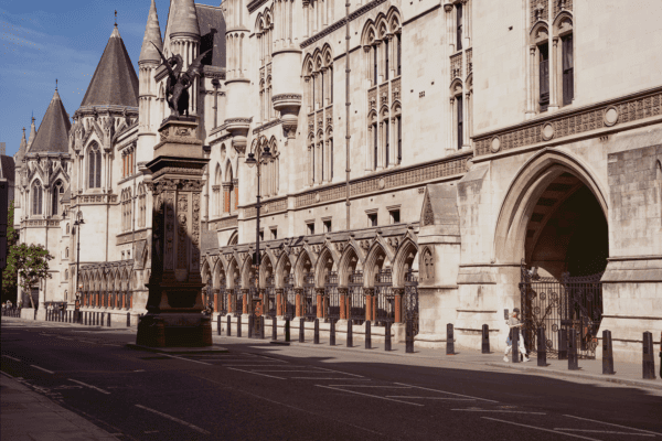 An exterior photo of the Royal Courts of Justice, with a statue of a dragon in front