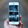A hand is holding a smartphone. On the screen is an animated image of the characters in the story.