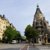 A photograph of Stureplan in Stockholm. The neo gothic buildings stretch upwards toward a blue sky.